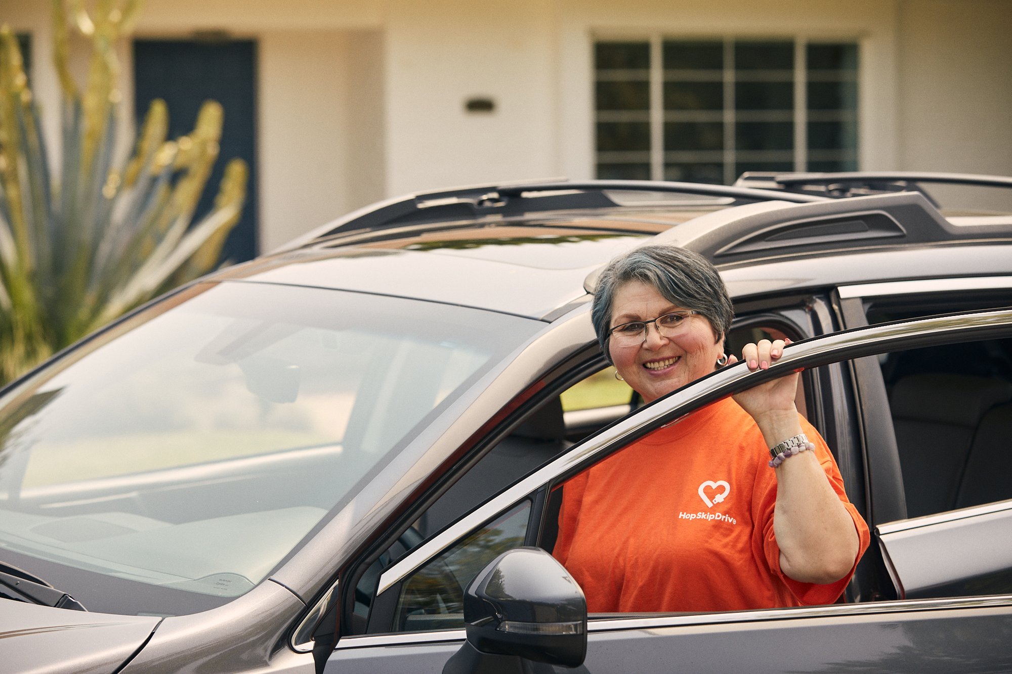 Woman standing with the car she uses to make extra cash driving